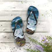 Flip-flops with ocean wave and rocky shore design on white wooden planks.