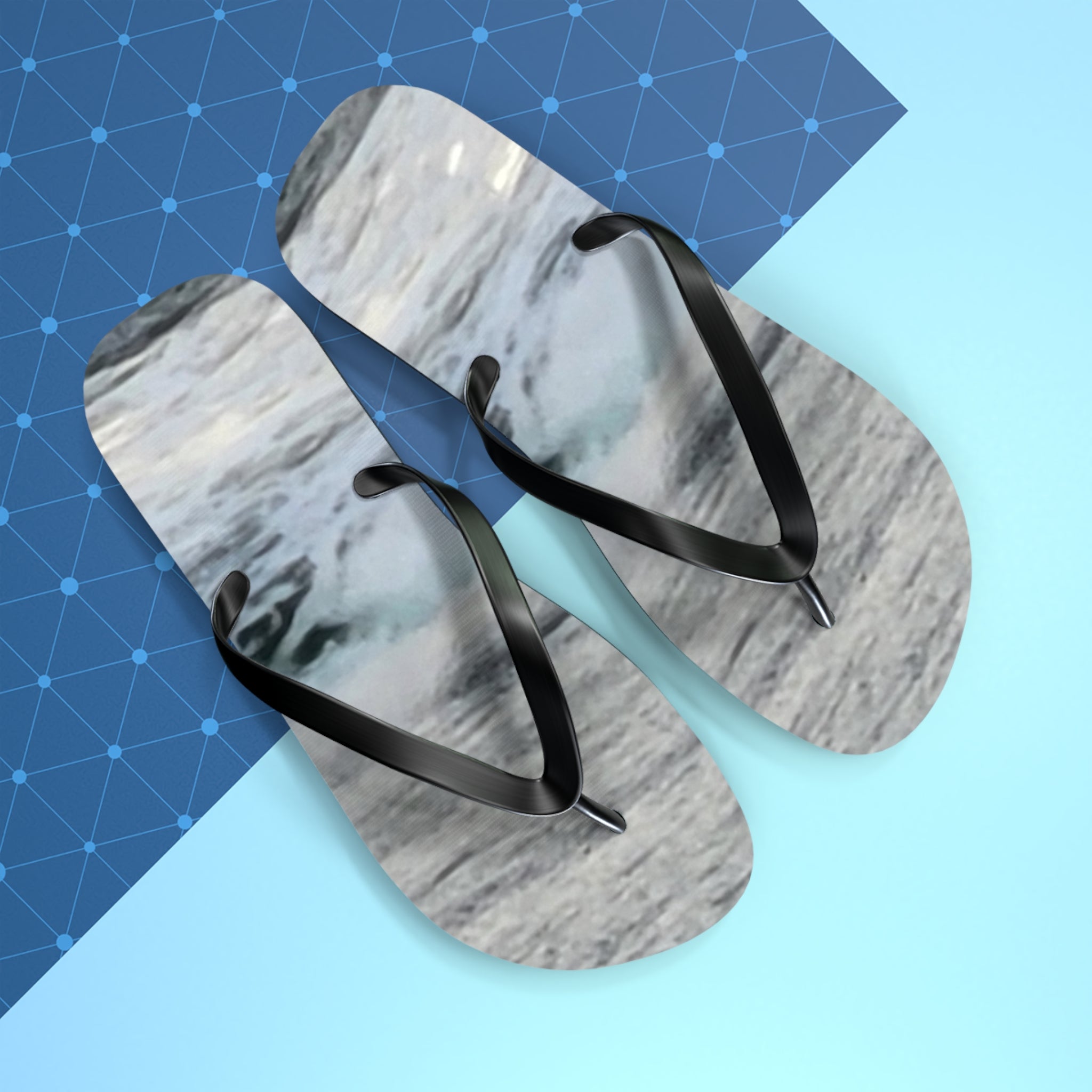 Flip-flops with abstract marble pattern on a light blue background.