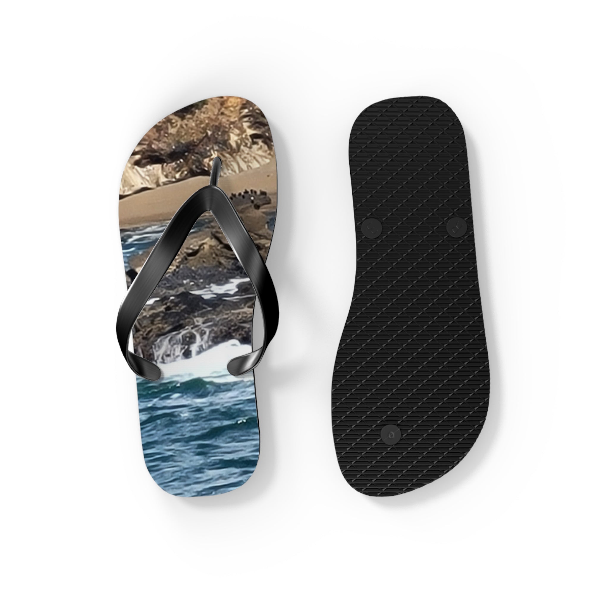 Black flip-flops with a beach scene printed on the sole.