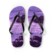 Purple flip-flops with a rocky ocean wave design on a white background.