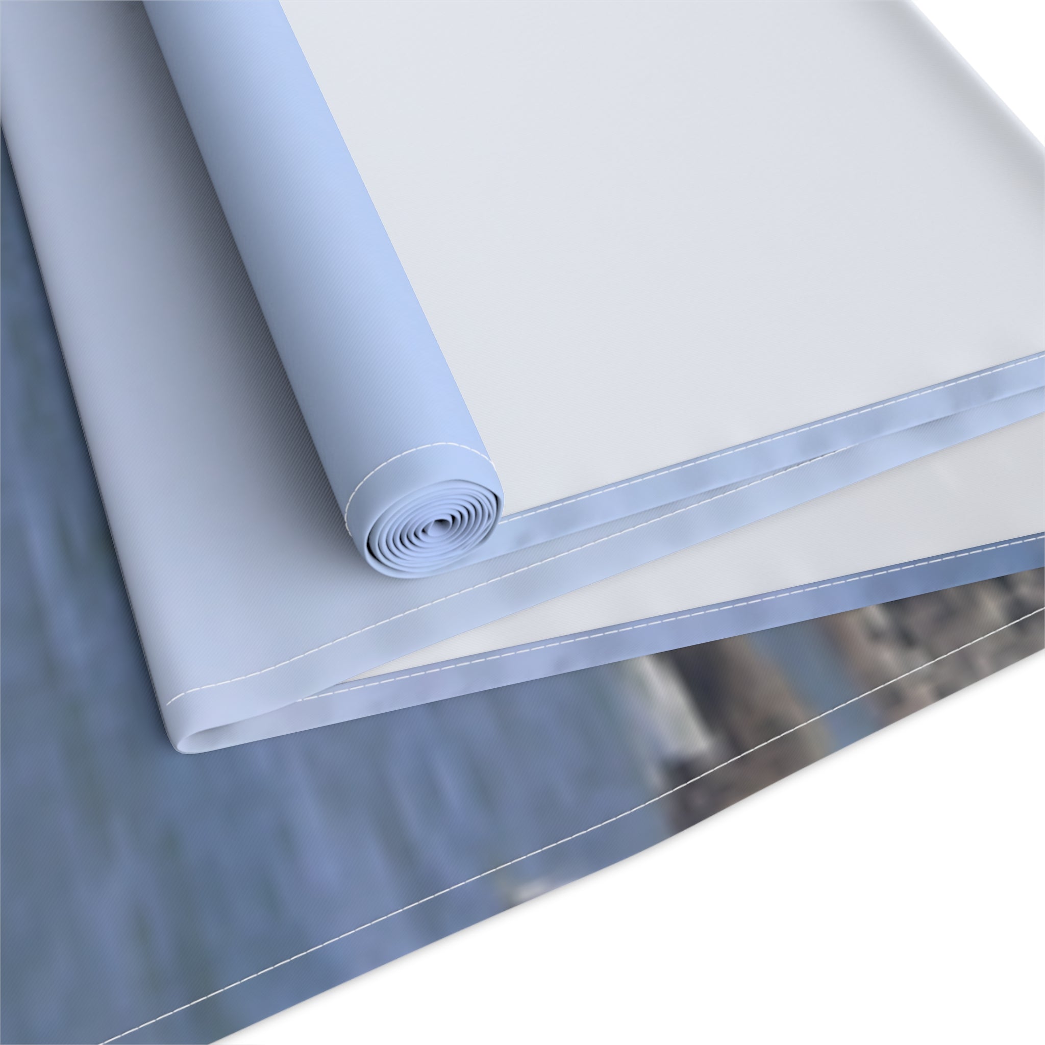Rolled fabric in light blue and white with visible stitching.