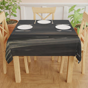 Dark tablecloth with abstract white text, set on a table with plates.