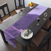 Purple abstract landscape table runner on a dining table with place settings.