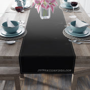 Black table runner with "JKCREATIONSFIND.COM" text on a wooden table.