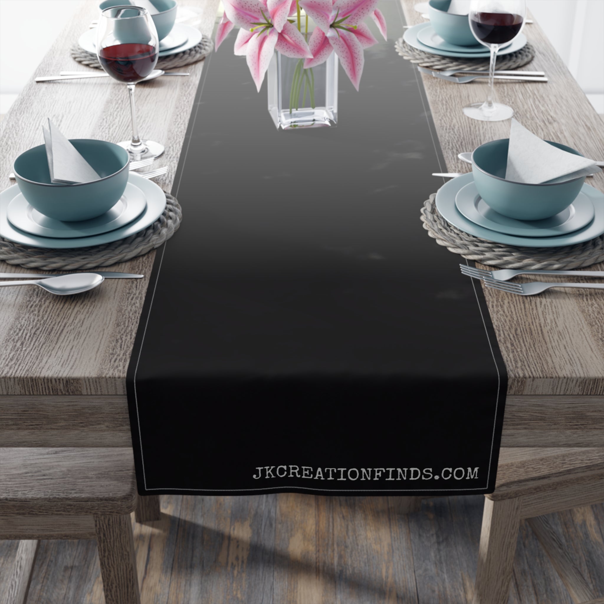 Black table runner with "JKCREATIONSFIND.COM" text on a wooden table.