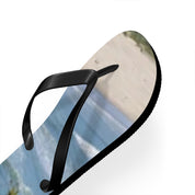 Black flip-flop with a beach and ocean scene printed on the sole.