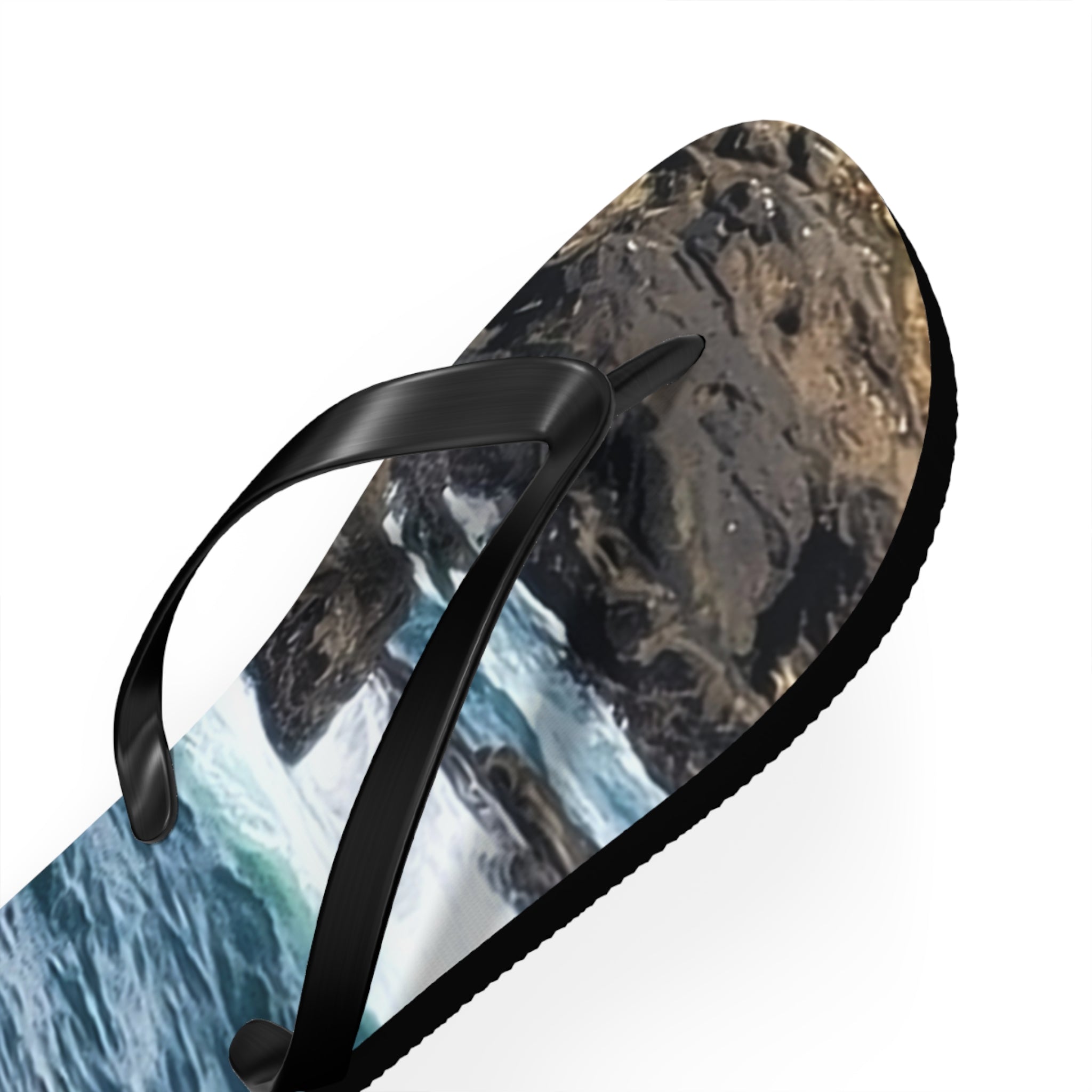 Flip-flops with a dynamic ocean and rocky shore scene print.