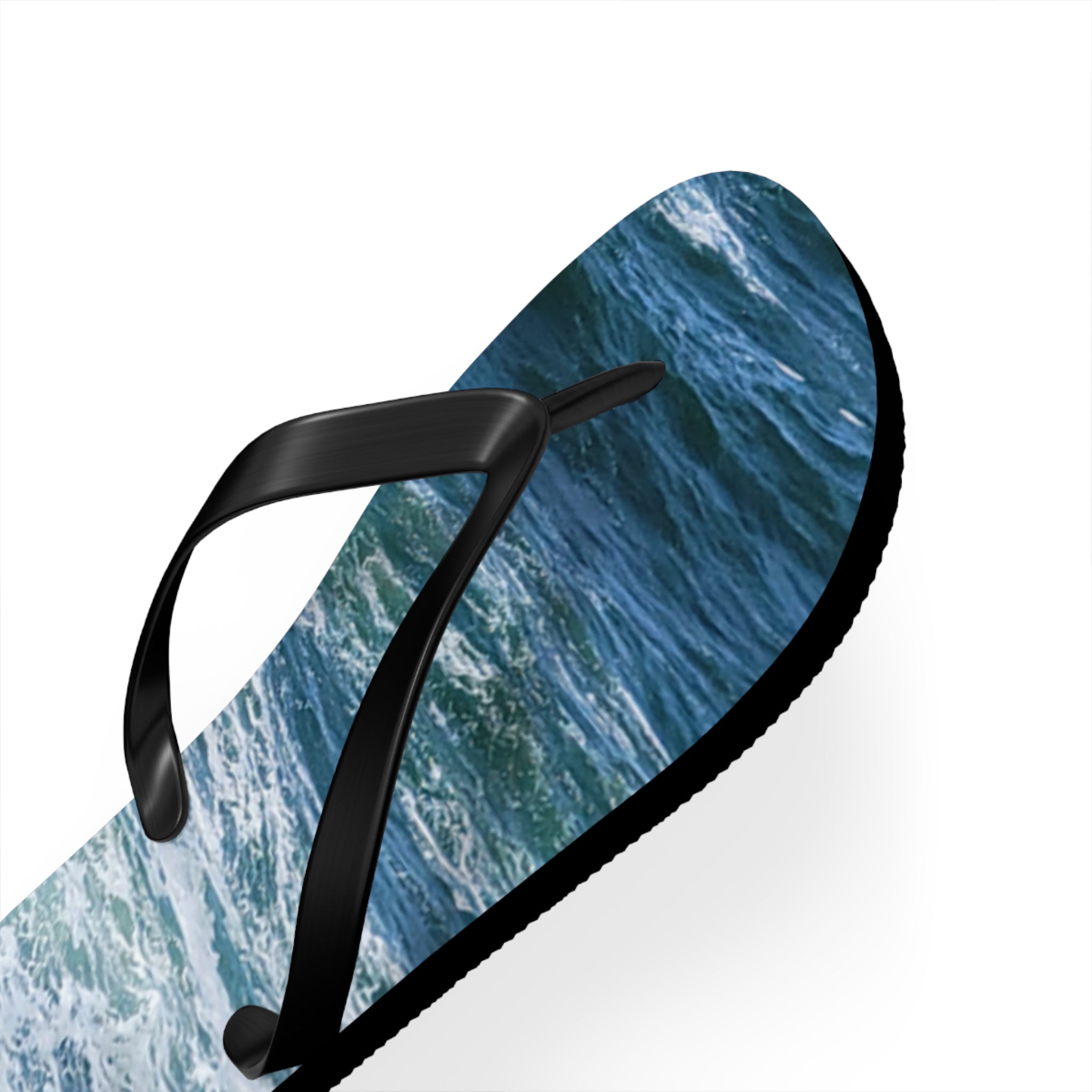 Black flip-flop with a close-up ocean wave pattern.