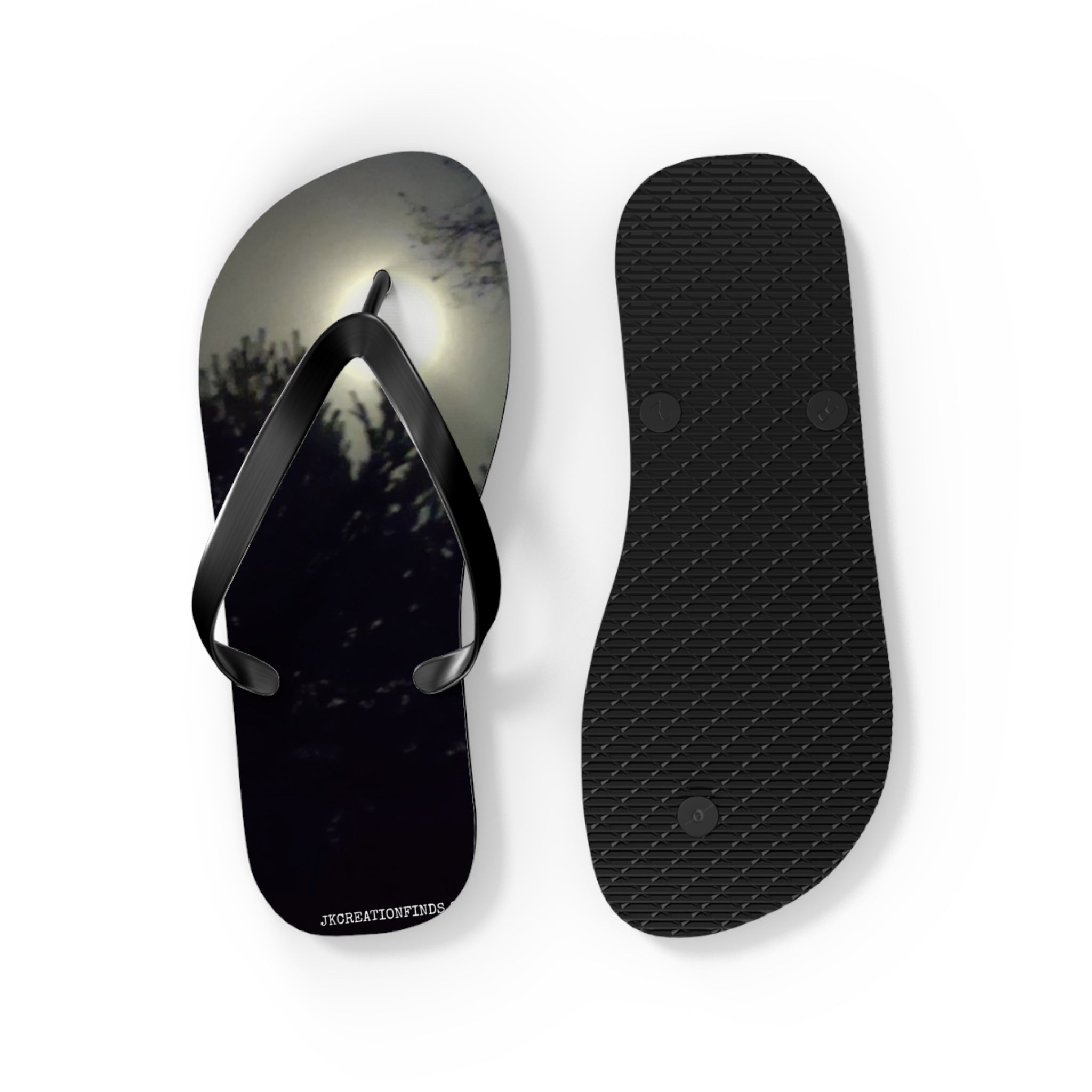 Flip-flops with a moonlit forest scene on the left strap and textured sole on the right.