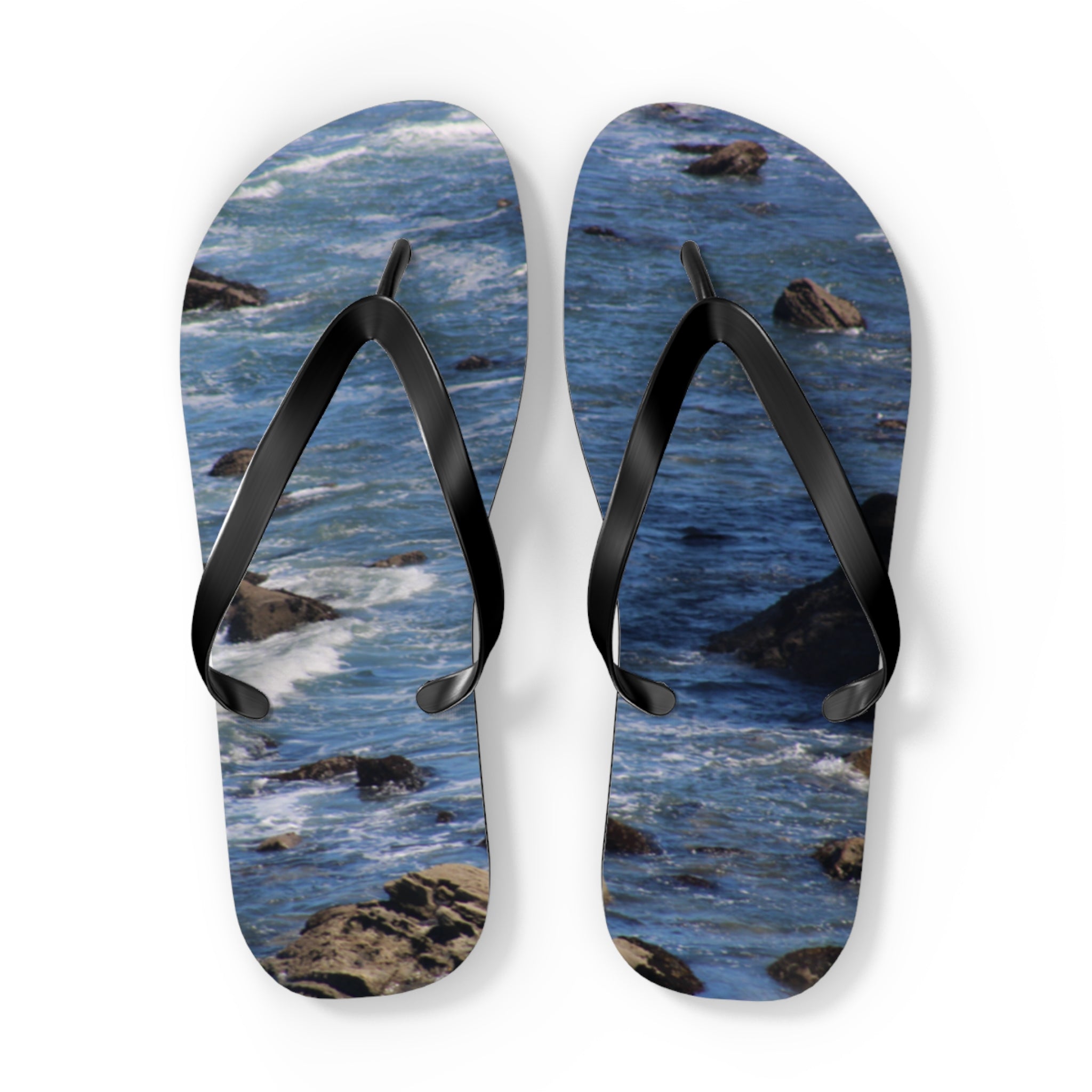 Flip-flops with a rocky ocean wave pattern on white background.