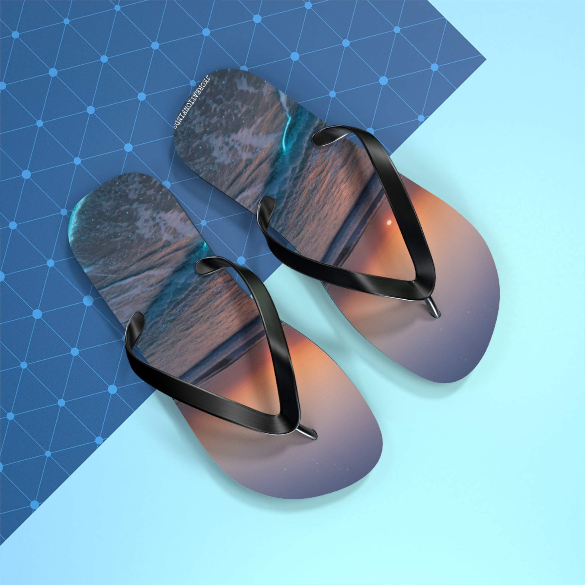 Flip-flops with ocean sunset design and textured blue background.