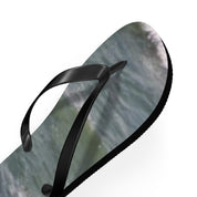 Black flip-flop with a swirling blue and green ocean wave pattern on the sole.