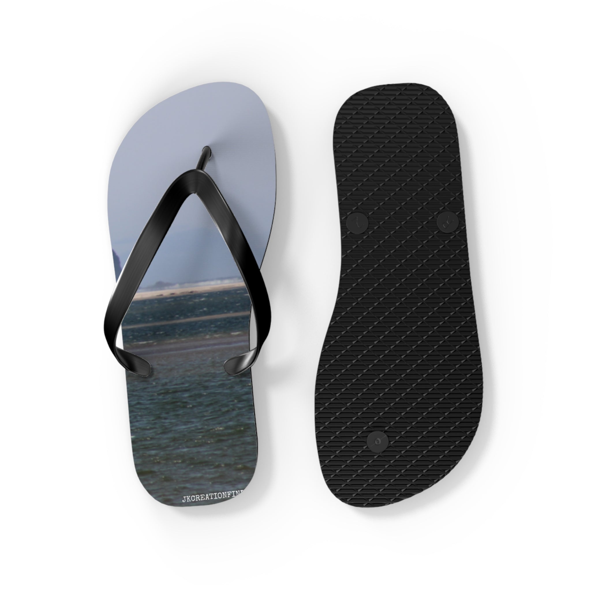 Flip flops with beach landscape on one sole, plain black on the other.