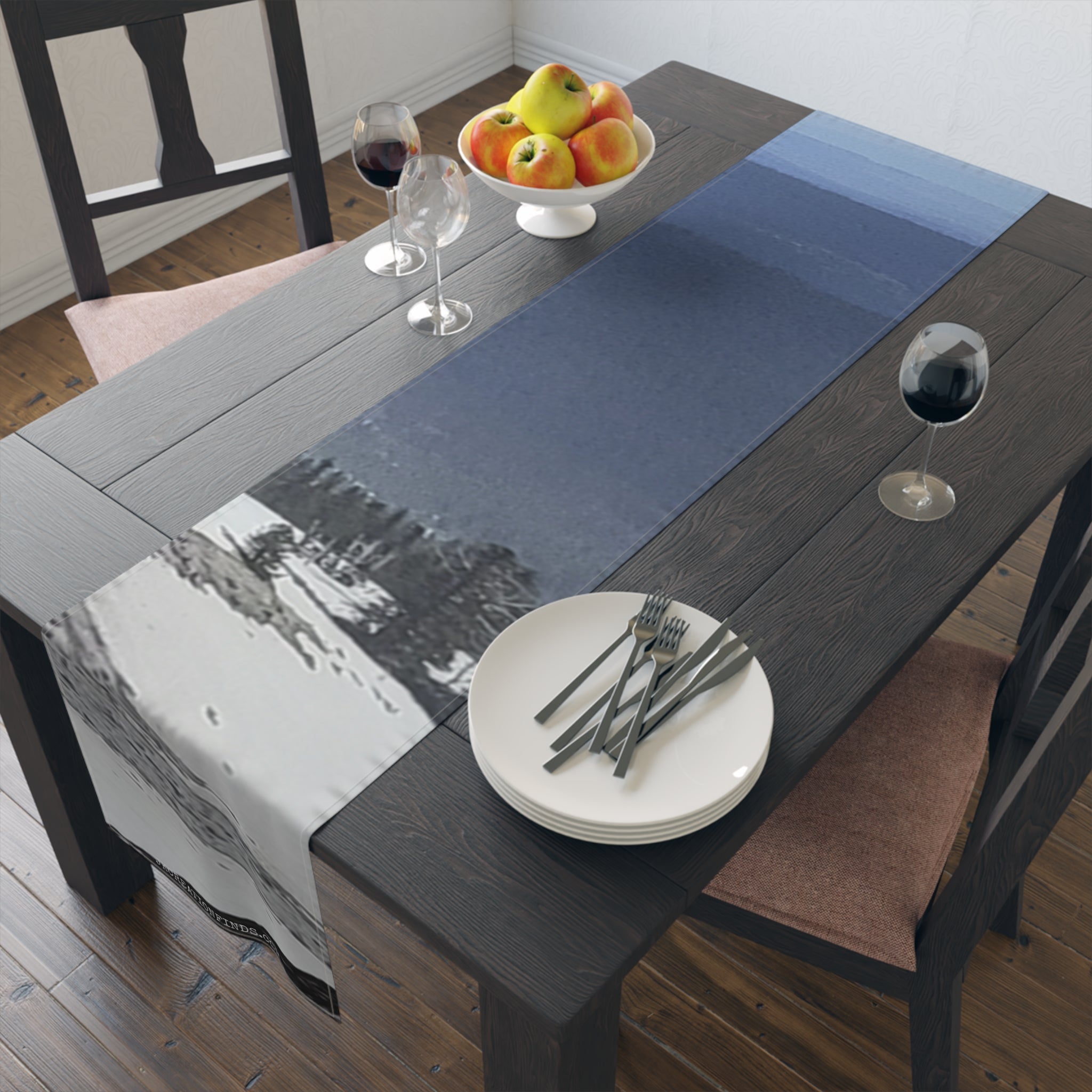 Dark wooden dining table with a dark blue and white landscape patterned table runner.